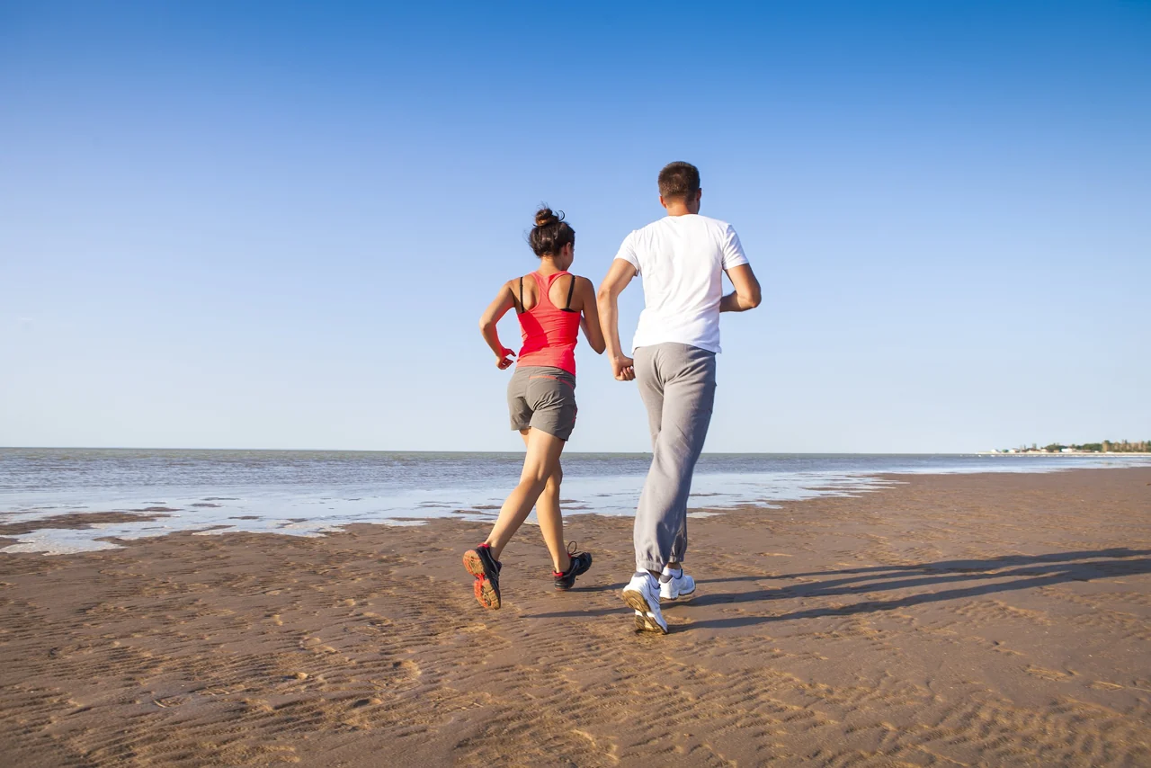 Two people running on a beach